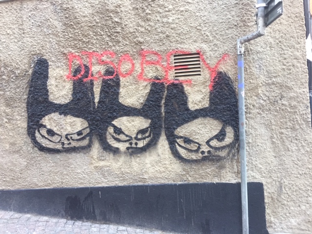 Graffiti med arga figurer och texten DIsobey.